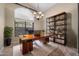 Home office with large desk, shelving, stylish decor, and natural light at 6959 E Red Hawk Cir, Mesa, AZ 85207