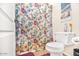 The bathroom features a standard toilet next to a shower with a floral shower curtain at 8615 S 45Th Gln, Laveen, AZ 85339
