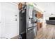 Modern stainless steel refrigerator stands alongside the kitchen entrance and rich hardwood style floors at 8615 S 45Th Gln, Laveen, AZ 85339