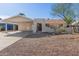 Single-story home featuring desert landscaping, carport and arched entryway with security gate at 8749 W Clarendon Ave, Phoenix, AZ 85037