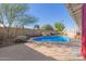Backyard pool area with rock waterfall feature, surrounded by desert landscaping and a tall block fence at 8749 W Clarendon Ave, Phoenix, AZ 85037