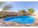 Sparkling blue swimming pool with rock waterfall feature, and a well-maintained concrete patio at 8749 W Clarendon Ave, Phoenix, AZ 85037