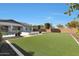 Well-maintained backyard featuring artificial grass, rock landscaping, pool, spa, and trimmed trees at 24437 N 94Th Ave, Peoria, AZ 85383