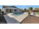 Backyard view featuring a pool, spa, covered patio, artificial grass, and rock landscaping at 24437 N 94Th Ave, Peoria, AZ 85383