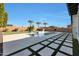 Modern backyard featuring a pool, spa, tiled decking, and palm trees against a clear blue sky at 24437 N 94Th Ave, Peoria, AZ 85383