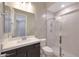 Modern bathroom featuring a single sink vanity, shower with tile surround and glass door at 24437 N 94Th Ave, Peoria, AZ 85383