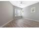Bright bedroom features wood-style flooring, plantation shutters, and ceiling fan at 24437 N 94Th Ave, Peoria, AZ 85383