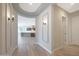 The foyer leads to an open layout with a light gray color palette, wood floors, and elegant sconces at 24437 N 94Th Ave, Peoria, AZ 85383