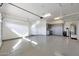 Spacious garage with epoxy flooring, ample storage cabinets and shelving at 24437 N 94Th Ave, Peoria, AZ 85383