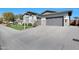 Paver driveway leading to a spacious three-car garage, landscaped yard, and a well-maintained exterior at 24437 N 94Th Ave, Peoria, AZ 85383