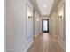 Light-filled hallway with decorative wall sconces and wood-look flooring at 24437 N 94Th Ave, Peoria, AZ 85383