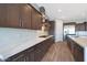 Modern kitchen features stainless steel appliances, stone countertops, and sleek, dark cabinetry at 24437 N 94Th Ave, Peoria, AZ 85383