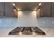 Close-up of a gas range with light backsplash and stainless steel hood at 24437 N 94Th Ave, Peoria, AZ 85383