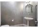 Chic powder room features pedestal sink with modern faucet and decorative mirror at 24437 N 94Th Ave, Peoria, AZ 85383