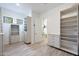 Large walk-in closet with custom shelving and storage, plus doorway to bathroom at 24437 N 94Th Ave, Peoria, AZ 85383