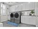 This laundry room is equipped with a front loading washer and dryer and white cabinets at 10134 W Cashman Dr, Peoria, AZ 85383