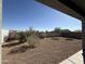 Low maintenance backyard is gravel with mature bushes and trees at 1075 W Avalon Canyon Dr, Casa Grande, AZ 85122