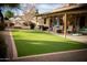 A well maintained backyard featuring a covered patio and artificial grass at 1119 S Presidio Dr, Gilbert, AZ 85233