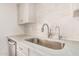 Close-up of a kitchen sink with white cabinets, tile backsplash, and light countertops at 11616 S Jokake St, Phoenix, AZ 85044