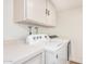 Bright laundry room featuring a white washer and dryer with overhead cabinet at 11616 S Jokake St, Phoenix, AZ 85044