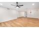 Spacious living room featuring wood-look flooring, a ceiling fan, and fresh white walls at 11616 S Jokake St, Phoenix, AZ 85044