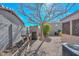 Gravel backyard features a shed, block wall, a built-in bbq grill and a tree without leaves at 12721 W Valentine Ave, El Mirage, AZ 85335