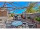 Charming backyard with barbecue, firepit, mosaic table and mature trees creating a private space at 12721 W Valentine Ave, El Mirage, AZ 85335