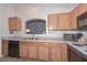 Bright kitchen featuring wood cabinets, neutral countertops, and black appliances at 12721 W Valentine Ave, El Mirage, AZ 85335