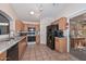 Functional kitchen with oak cabinets, black appliances, and tile floors at 12721 W Valentine Ave, El Mirage, AZ 85335