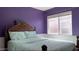 Bedroom features a large bed, window, and bright purple walls at 1298 S 222Nd Ln, Buckeye, AZ 85326