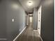 A bright and spacious hallway, featuring modern gray walls and durable vinyl floors, connecting various rooms at 1298 S 222Nd Ln, Buckeye, AZ 85326