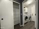 Laundry room with ample storage, including wire shelving and overhead cabinets, and modern appliances at 1298 S 222Nd Ln, Buckeye, AZ 85326