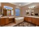 Bathroom features double sinks, a large soaking tub, and a glass-block window at 13117 W Micheltorena Dr, Sun City West, AZ 85375