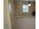 Spacious carpeted bedroom with a window and decorative chandelier at 13117 W Micheltorena Dr, Sun City West, AZ 85375