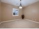 A bright, empty bedroom features neutral walls, plush carpet, and a large, shuttered window at 13117 W Micheltorena Dr, Sun City West, AZ 85375