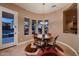 Dining area features a round table, decorative rug, and a view to the outside pool at 13117 W Micheltorena Dr, Sun City West, AZ 85375