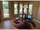 Cozy dining area with pool view, featuring a round table, four chairs, and a stylish overhead light fixture at 13117 W Micheltorena Dr, Sun City West, AZ 85375