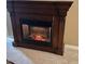 Close up of the fireplace, showcasing ornate wood detailing and an electric insert at 13117 W Micheltorena Dr, Sun City West, AZ 85375