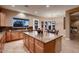 Modern kitchen featuring a center island, granite countertops, and views of the backyard and dining space at 13117 W Micheltorena Dr, Sun City West, AZ 85375