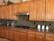 A well-lit kitchen featuring wooden cabinets, granite countertops, and stainless steel appliances at 13117 W Micheltorena Dr, Sun City West, AZ 85375