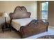 Beautiful main bedroom featuring an ornate wood bed frame, side table, and plush carpeting at 13117 W Micheltorena Dr, Sun City West, AZ 85375