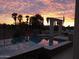 Beautiful pool reflecting a stunning sunset sky and palm trees at 13117 W Micheltorena Dr, Sun City West, AZ 85375