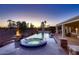 Backyard with swimming pool, spa, fire pit, and well-manicured landscaping at dusk at 13117 W Micheltorena Dr, Sun City West, AZ 85375