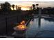 Luxury pool with fire bowls, lights, and sunset views at 13117 W Micheltorena Dr, Sun City West, AZ 85375