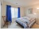 Cozy bedroom with a nautical-themed quilt, wood chair, and a window with blinds at 1371 E Cactus Bloom Way, Casa Grande, AZ 85122