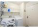 Functional laundry room with white washer, dryer, wire shelving, and a door to outside at 1371 E Cactus Bloom Way, Casa Grande, AZ 85122