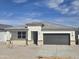 Charming single-story home with a gray roof, neutral stucco exterior, and a two-car garage at 15406 W Hackamore Dr, Surprise, AZ 85387