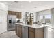 Bright kitchen featuring stainless steel appliances, quartz countertops, island with seating, and dark wood cabinets at 15406 W Hackamore Dr, Surprise, AZ 85387