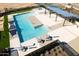 Aerial view of a community pool with lounge chairs, a covered seating area, and well-maintained landscaping at 15570 W Williams St, Goodyear, AZ 85338