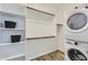 Laundry room featuring a stackable washer and dryer and lots of built in shelving at 15751 W Pioneer St, Goodyear, AZ 85338